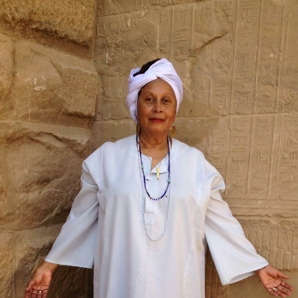 An image of IONE, dressed in white robes and a white head wrap.