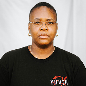A headshot of Darian Henry, with glasses and a black shirt on.