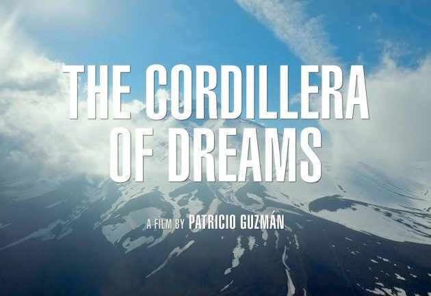 An image of the snow-capped Andes of Chile with blue sky and clouds. It is a production still with white text reading: "The Cordillera of Dreams," A film by Patricio Guzman.