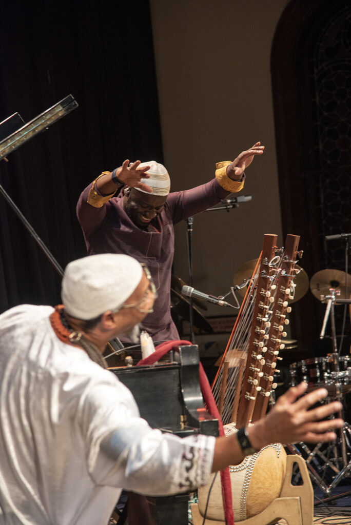 An action shot of Seckou Keita playing the Kor, featuring Omar Sosa
