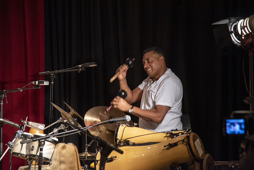 Gustavo Ovalles performing on the drums and other various percussion instruments.