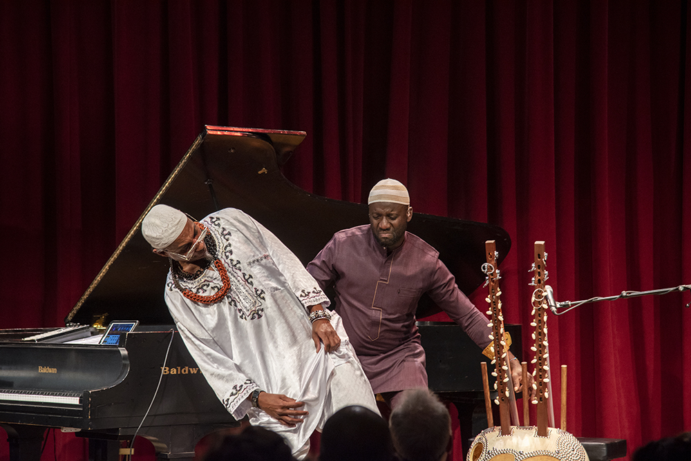 An action shot of Seckou Keita playing the Kora, featuring Omar Sosa as well