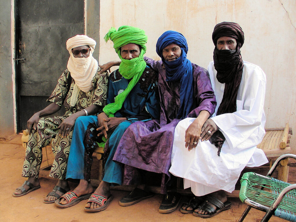 a group photo of the four musicians in Al Bilali Soudan, all wearing long, loose tunics and head wraps