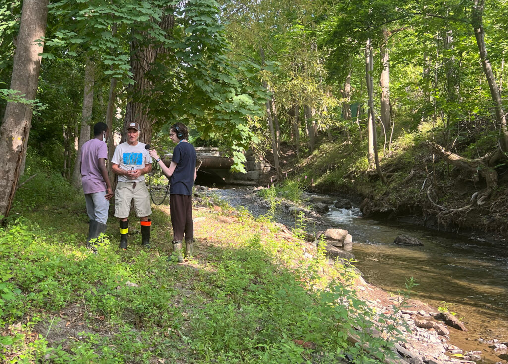 Two Water Justice Lab youth fellows interview Doug Reed on the banks of the Wynants Kill. 