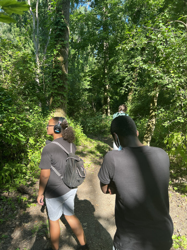 Sanctuary youth fellows walk on a nature trail at the Papscanee Island nature preserve. 