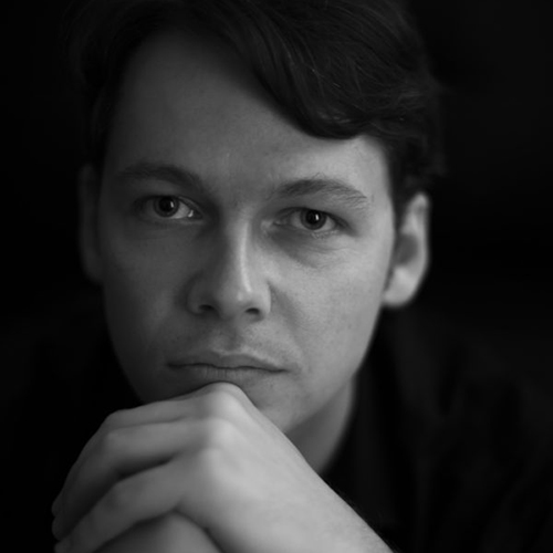 A close-up headshot of Mihai Marica in black and white, the cello player. 
