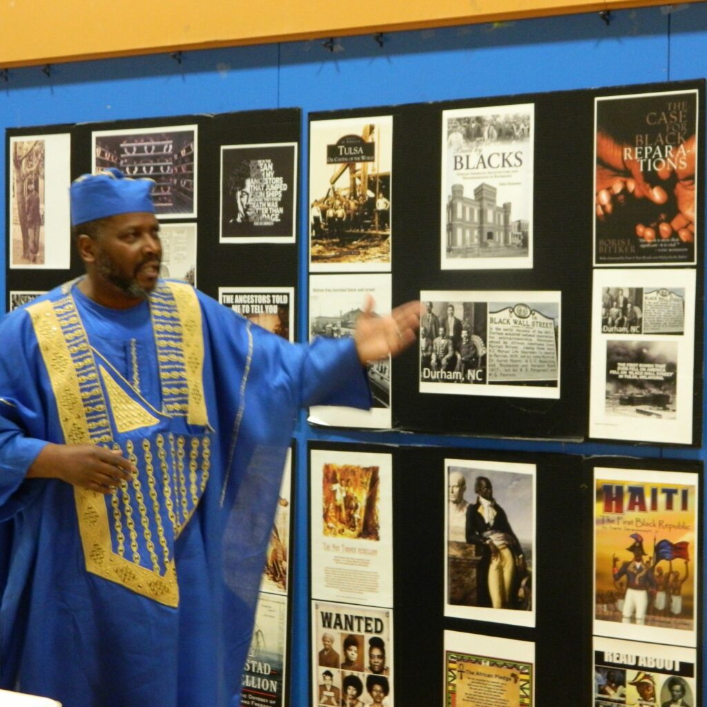 Malik Muhammad gesturing to his installation of Black History 
