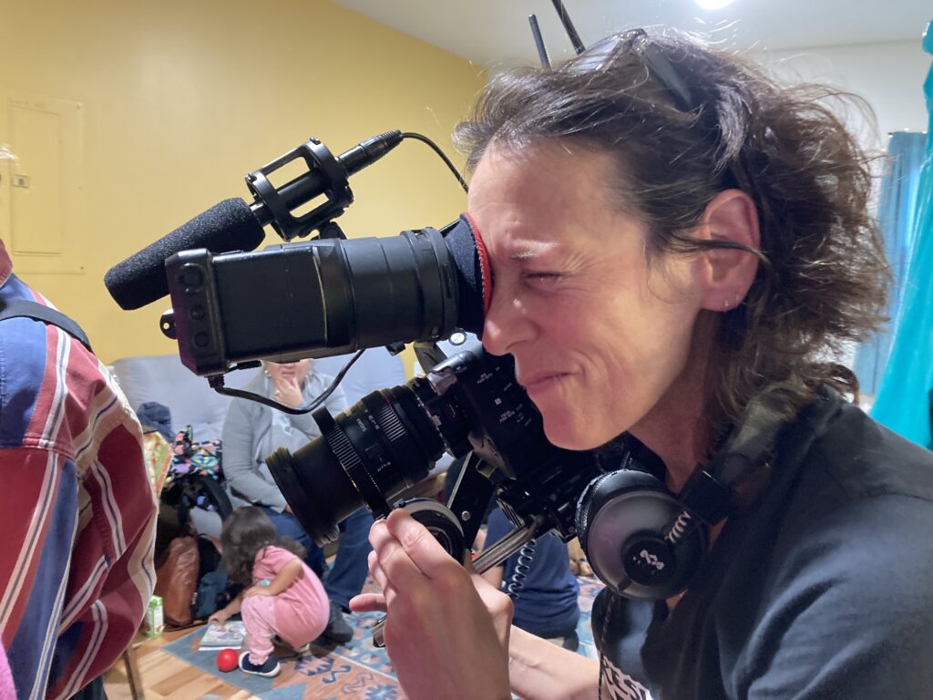 A close up photo of videographer Jill Malouf filming the Seed Rematriation workshop.