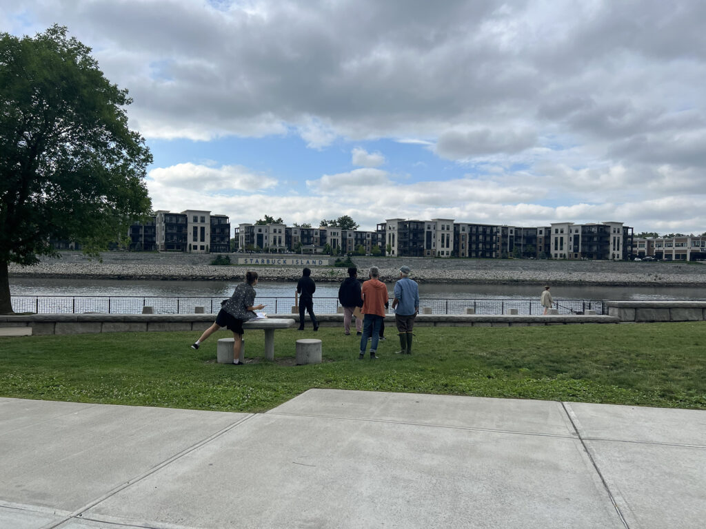 Five people look out at the Hudson River from Troy's Riverfront Park. 