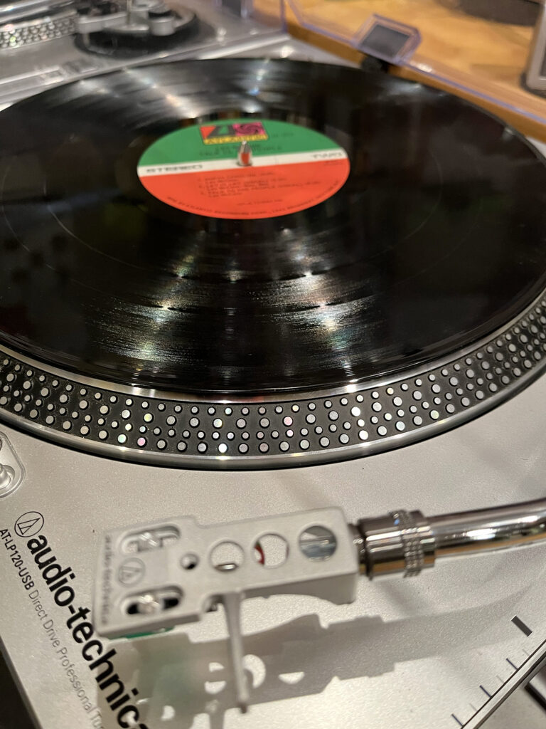 a record with a green, white, and red label sits on a turntable
