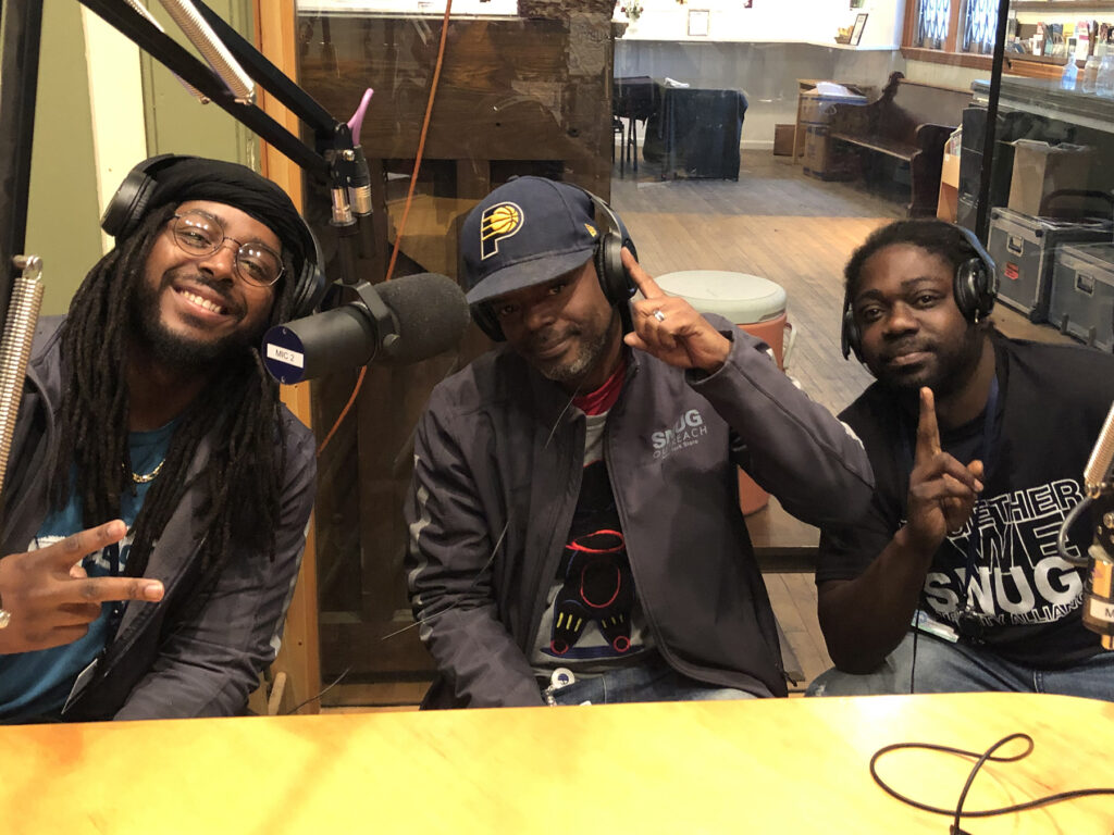 three members of SNUG smile at the camera after an interview in the studio. From left: Ozy, Jimmie, Desmond. 