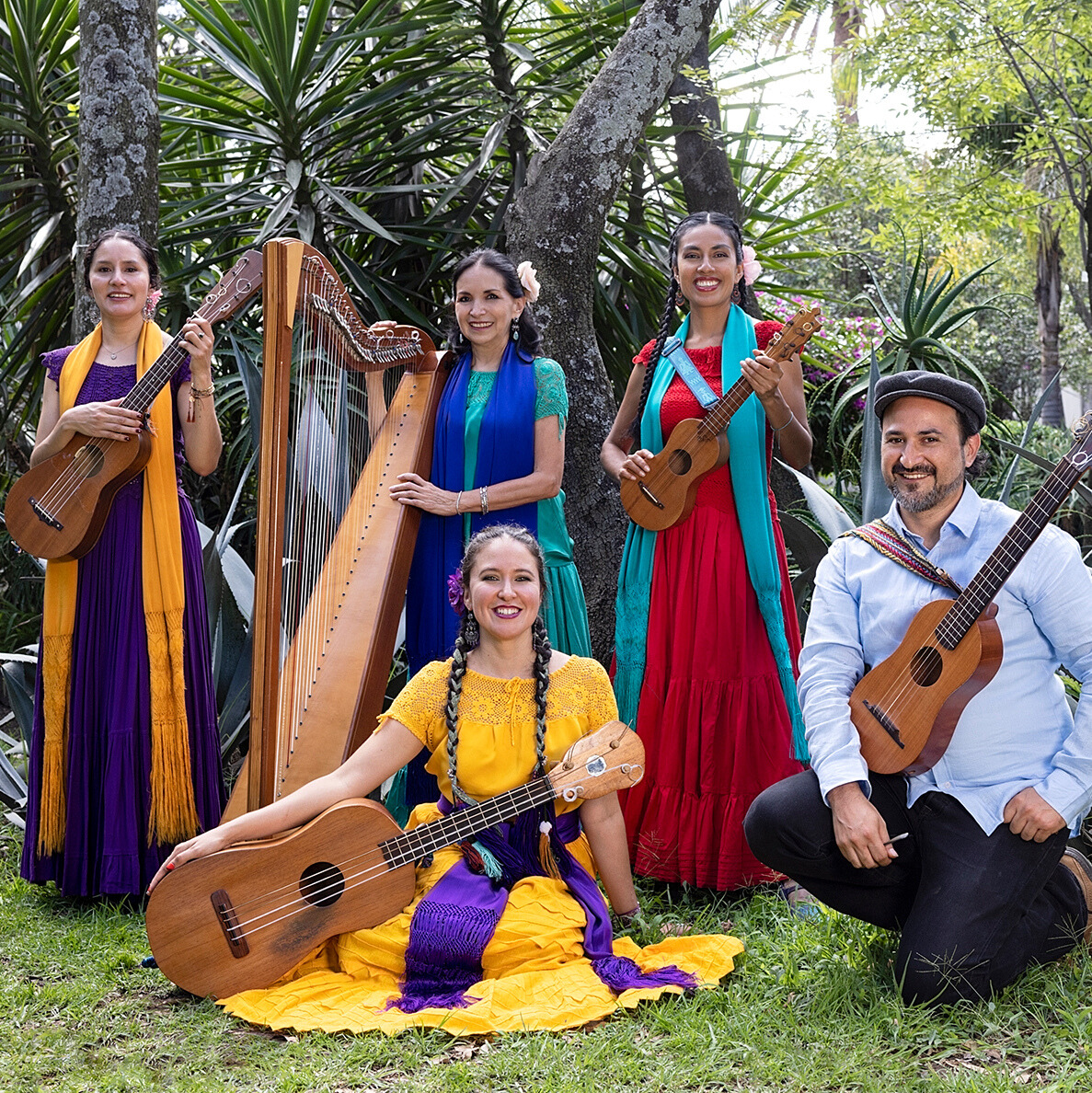 A photo of all the members of Caña Dulce y Caña Brava in vibrant clothing while positioned next to their respective instruments.